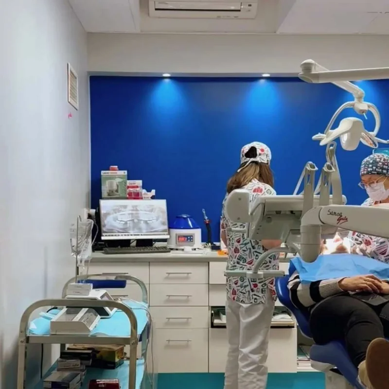 ODONTOFAMILYko kabinetea, horma urdinarekin, hortz aulkiarekin eta lan gunearekin